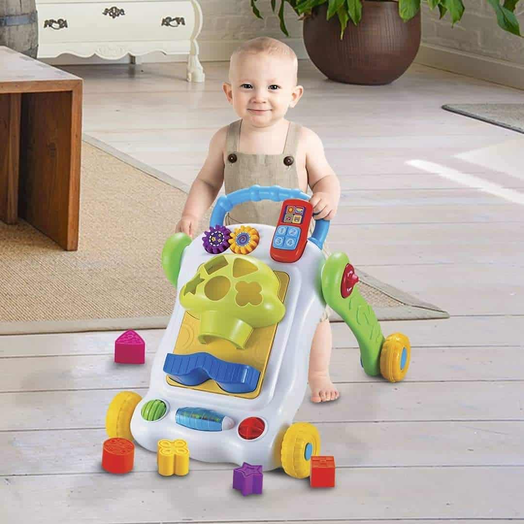 guralica za prohodavanje sa interaktivnim elementima u različitim oblicima i bojama sa detetom koje gura hodalicu