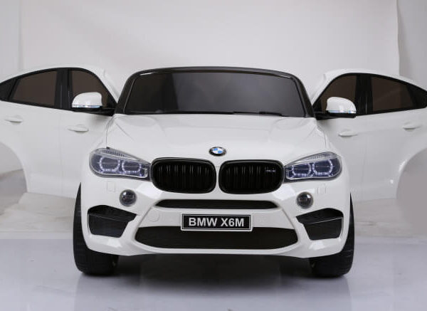 BMW X6 M Dvosed Licencirani na akumulator sa kožnim sedištima i mekim gumama beli sa otvorenim vratima slikan sa prednje strane