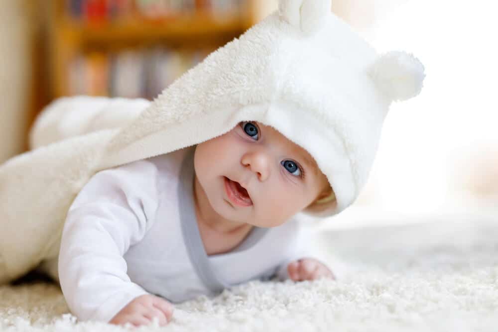 beba sa belom kapicom na belom ćebetu